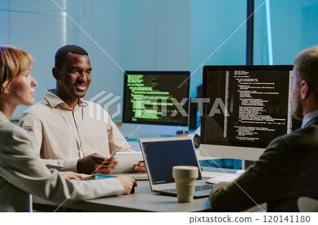 Group of African American and Caucasian data security specialists discussing test results during meeting in office 120141180
