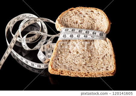 slice of bread tied with measurement tape on black slice of bread tied with measurement tape on black 120141605