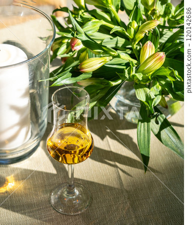 Amaretto almond liquor, sweet alcohol drink, brown Italian liquor made from apricot kernels, on summer table 120142686