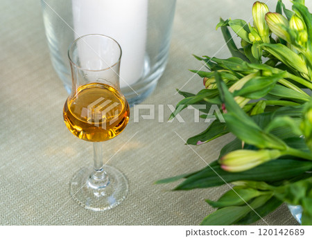 Amaretto almond liquor, sweet alcohol drink, brown Italian liquor made from apricot kernels, on summer table Amaretto almond liquor, sweet alcohol drink, brown Italian liquor made from apricot kernels, on summer table 120142689