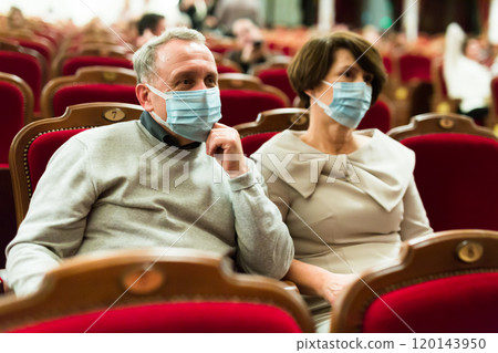 Caucasian couple senor and senora in antivirus mask in theater hall 120143950