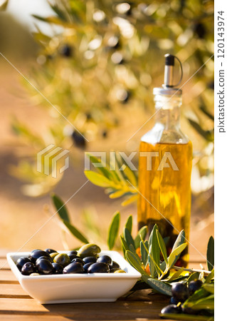 Green and black olives on table in olive grove Green and black olives on table in olive grove 120143974