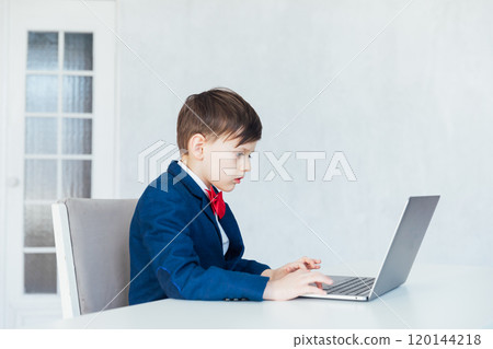 Schoolboy In Jacket At Desk Playing In Laptop Online 120144218