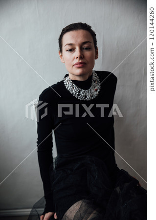 Portrait of a beautiful fashion woman 40 years old in a black dress 120144260