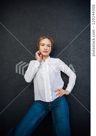 Beautiful fashionable slender woman in jeans and blouse walking the streets Beautiful fashionable slender woman in jeans and blouse walking the streets 120144308