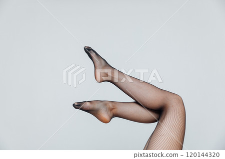 Beautiful female legs in black tights stockings on a white background 120144320