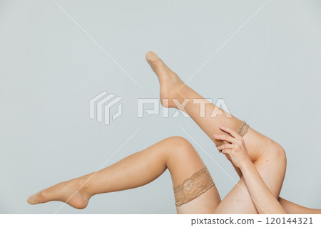 Beautiful women's legs in tights, stockings on a white background 120144321