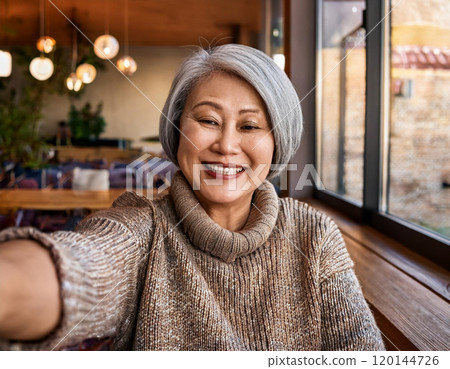 Happy Moments in Coffee Shop Mature Woman Influencer Vlogging or Taking Selfie in Coffee Shop 120144726
