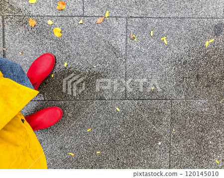 person wearing rubber red rain boots and yellow raincoat in rainy autumn day person wearing rubber red rain boots and yellow raincoat in rainy autumn day 120145010