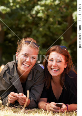 Girls together on the grass. Portrait of two young girls lying together the grass with copy space. Girls together on the grass. Portrait of two young girls lying together the grass with copy space. 120145105