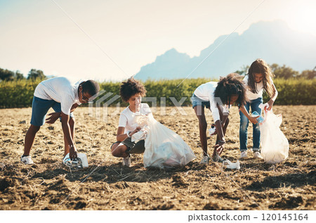 We all live here, we all need to keep it clean. Shot of a group of teenagers picking up litter off a field at summer camp. 120145164
