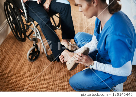 Starting her first day on the right foot. Shot of a young nurse putting on a senior womans shoes in a nursing home. Starting her first day on the right foot. Shot of a young nurse putting on a senior womans shoes in a nursing home. 120145445