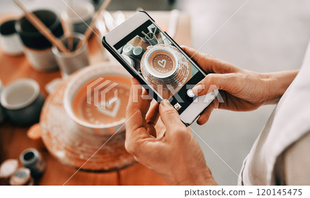 I have to post this on social media. Cropped shot of an unrecognizable woman standing and taking a picture of her pottery with her cellphone in her workshop. 120145475