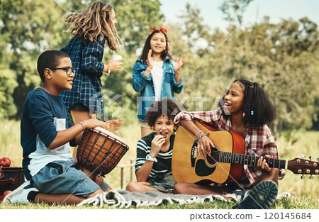 Happy childhood memories are made with happy music. Shot of a group of teenagers playing musical instruments in nature at summer camp. 120145684