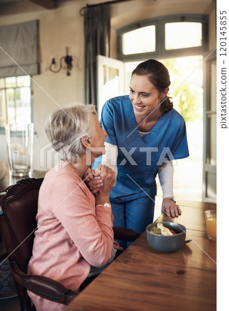 Please pass on my compliments to the chef. Shot of a young nurse checking up on a senior woman during breakfast at a nursing home. 120145855