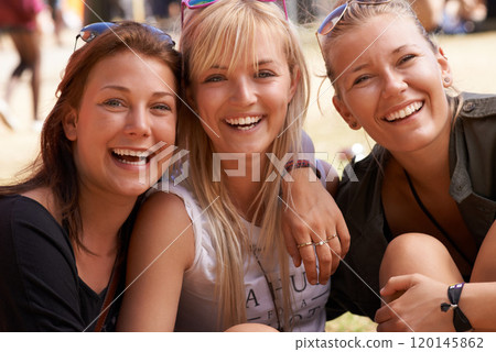 Hanging out with the girls. Portrait of three smiling friends sitting arm in arm and at a festival. Hanging out with the girls. Portrait of three smiling friends sitting arm in arm and at a festival. 120145862
