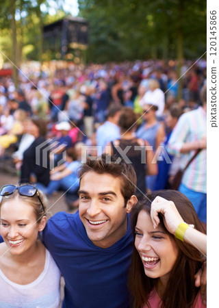 Friends at the festival. A group of smiling friends enjoying a music festival with crowd in the background. Friends at the festival. A group of smiling friends enjoying a music festival with crowd in the background. 120145866