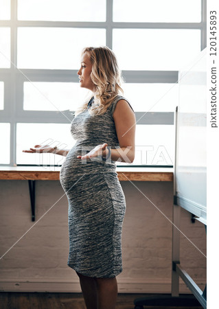 Managing her business and pregnancy. Shot of a pregnant businesswoman giving a presentation in the boardroom. 120145893