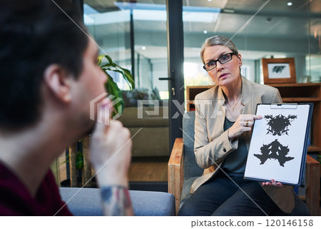 Gaining access into the subconscious mind. Shot of a mature psychologist conducting an inkblot test with her patient during a therapeutic session. 120146158