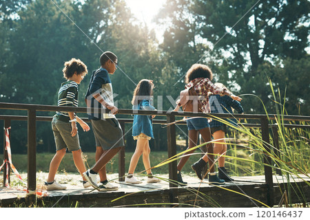 Adventure, here we come. Shot of a group of teenagers walking across a bridge in nature at summer camp. 120146437