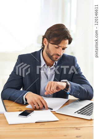 Almost time for my meeting. A handsome businessman looking at his watch while working on his laptop. Almost time for my meeting. A handsome businessman looking at his watch while working on his laptop. 120146611