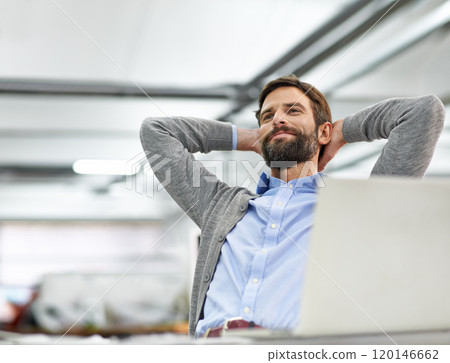 Hes hard at work on his laptop. A young businessman working on his laptop in the office. 120146662