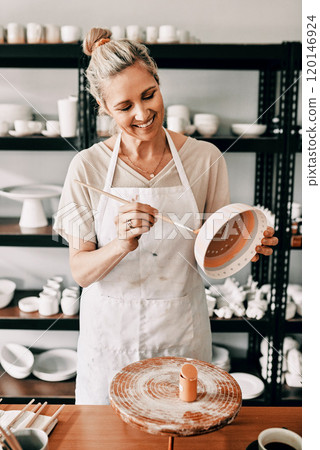 I am already so happy with how this looks. Cropped shot of an attractive mature woman standing alone and painting a pottery bowl in her studio. 120146924