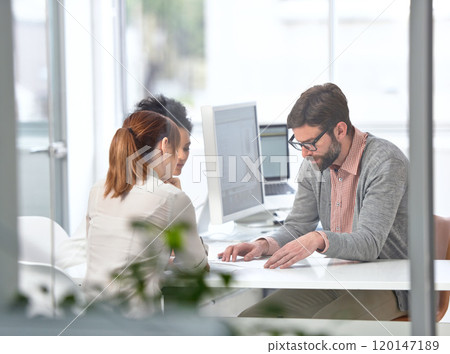 Teamwork gets business done. A group of businesspeople going over some plans together. 120147189