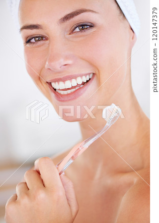 The most important part of my beauty routine. A lovely young lady holding a toothbrush while smiling. 120147379