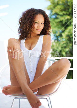 Relaxed and beautiful. Naturally gorgeous young woman looking at you suggestively while sitting on a chair outdoors. Relaxed and beautiful. Naturally gorgeous young woman looking at you suggestively while sitting on a chair outdoors. 120147435