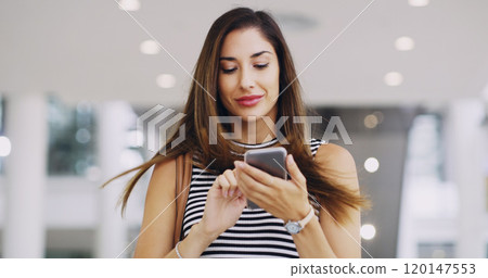 It pays to stay connected. Cropped shot of a young businesswoman using a smartphone while walking through a modern office. It pays to stay connected. Cropped shot of a young businesswoman using a smartphone while walking through a modern office. 120147553