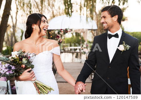 Young, free and in love. Shot of a happy newlywed young couple holding hands together outdoors on their wedding day. 120147589