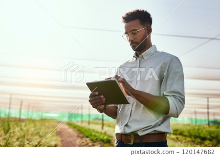 Its the only life for him. Cropped shot of a handsome young male farmer using a tablet while working on his farm. Its the only life for him. Cropped shot of a handsome young male farmer using a tablet while working on his farm. 120147682