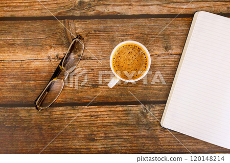Against wooden background, an open notebook planner sits next coffee espresso. Against wooden background, an open notebook planner sits next coffee espresso. 120148214