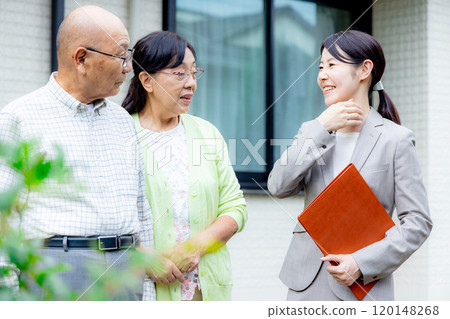 A woman showing a senior couple around their house 120148268