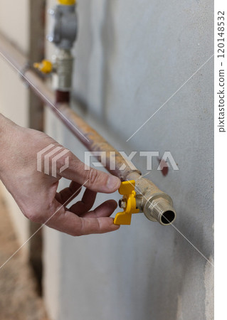 Male hand turns off the gas valve. Male hand turns off the gas valve. 120148532
