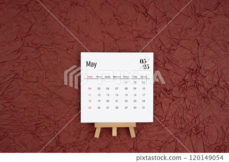 May 2025 calendar on red crumpled paper background. Directly above. May 2025 calendar on red crumpled paper background. Directly above. 120149054