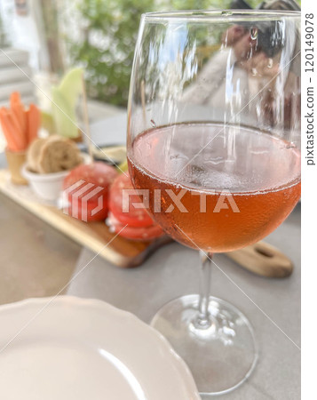 glass of rose or blush wine over starter plate on table glass of rose or blush wine over starter plate on table 120149078