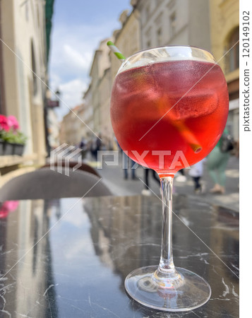 glass of alcoholic cocktail on marble table of open air cafe 120149102