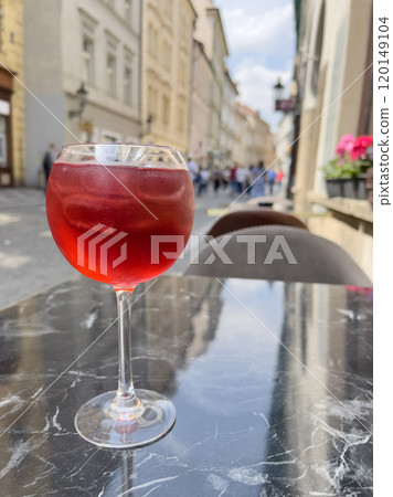 glass of alcoholic cocktail on marble table of open air cafe 120149104
