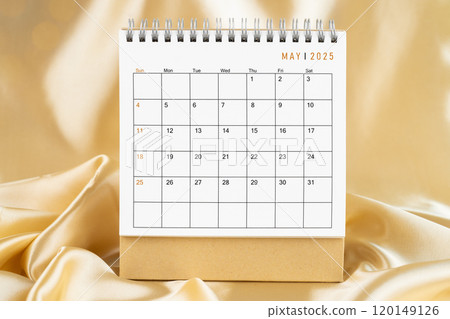 Front view of May 2025 desk calendar on gold silk. 120149126