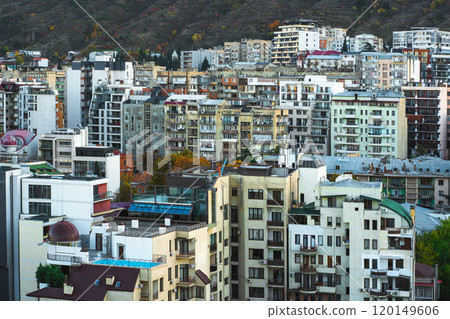 Urban panorama showcasing a vibrant cityscape with diverse architecture nestled against mountains during autumn 120149606