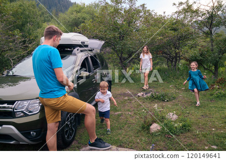 A joyful family happily enjoying quality time together outdoors, traveling in their car amidst beautiful nature 120149641