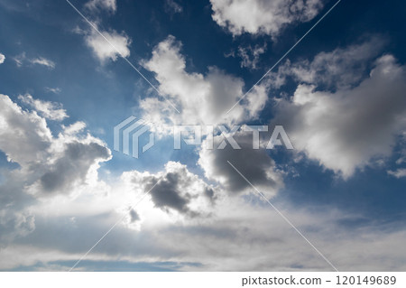 The suns rays are breaking through the cumulus clouds in the electric blue sky, creating a tranquil atmosphere in the natural landscape. 120149689
