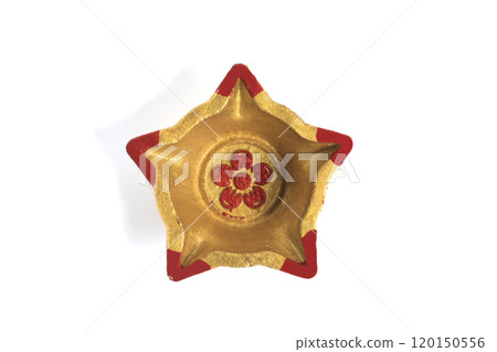 Top view of a star shaped decorative diwali oil lamp (diya) on white background 120150556