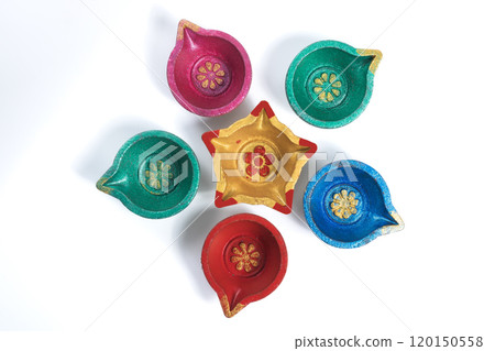 Top view of colorful Diwali diyas arranged in circle on white background 120150558