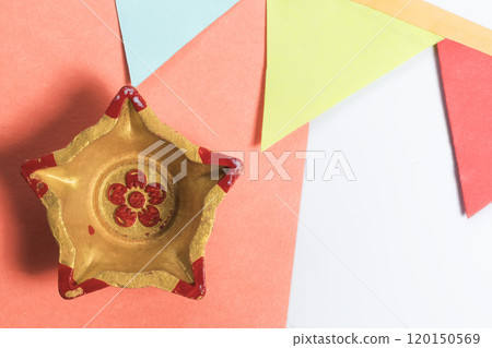 Colorful Golden Star Diyas on orange paper with decorative flag for Diwali celebration 120150569