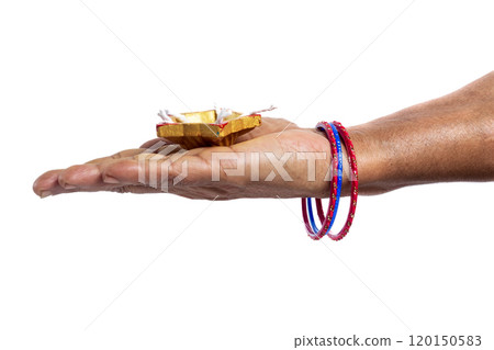 Indian woman holding Diwali oil lamp in palm with colorful bangles on white background. 120150583