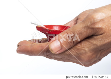 Elderly woman holding red candle on white background with clipping path Elderly woman holding red candle on white background with clipping path 120150587