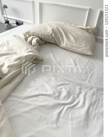 untidy bed with pillow and quilt in bedroom or hotel room interior untidy bed with pillow and quilt in bedroom or hotel room interior 120151321